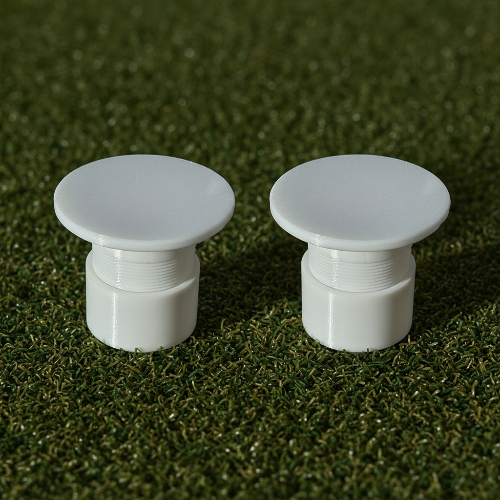 2 White Adjustable Golf Cup Inserts on Artificial Grass background