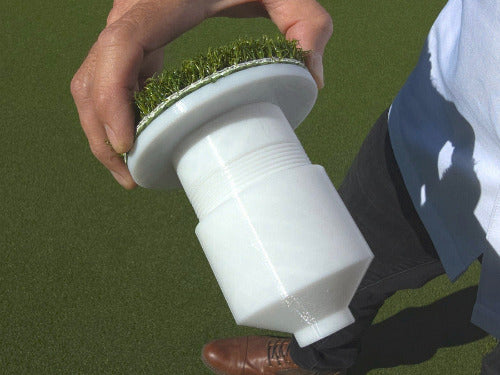 Adjustable Golf Cup Cover up close with SYNLawn artificial turf top, being held by a man standing on an artificial grass putting green 